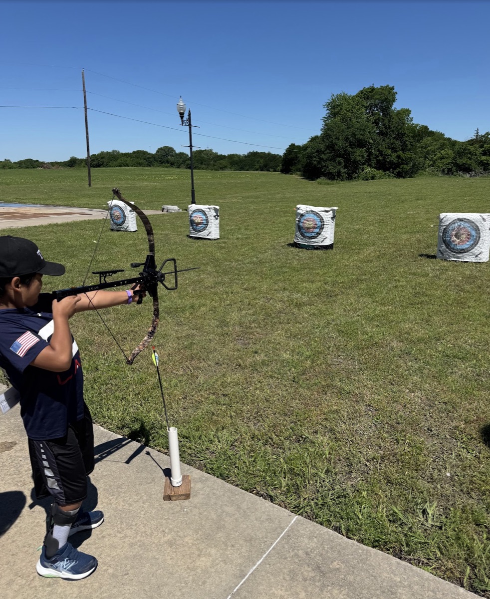 Ryle shooting compound bow at archery range