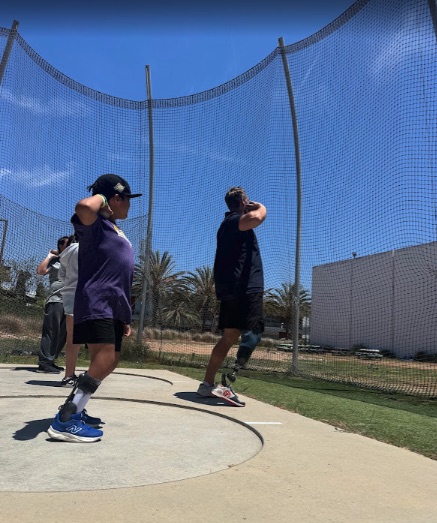 Ryle training in the discus cage alongside another thrower