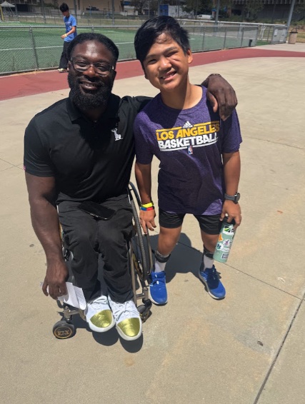 Ryle in his Lakers shirt with a coach courtside after practice