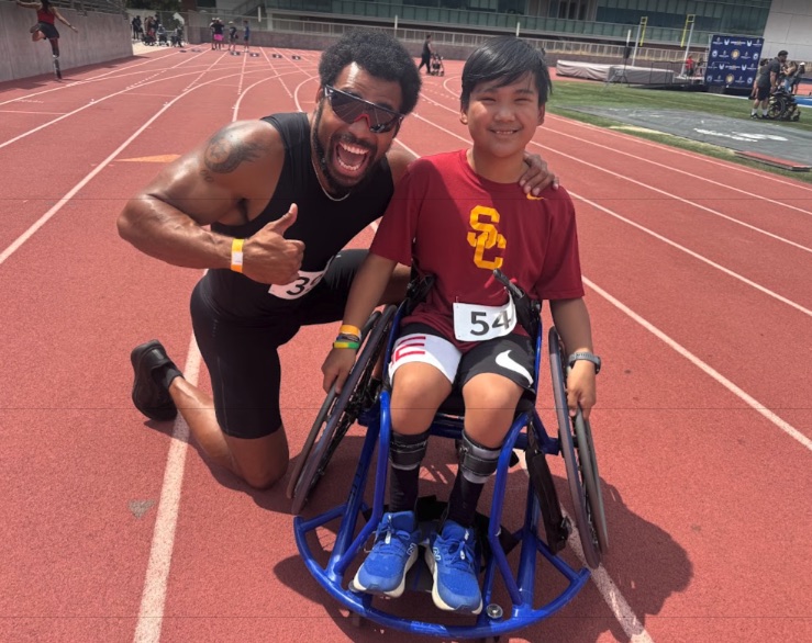 Ryle in his racing chair with a para sprinter at the track