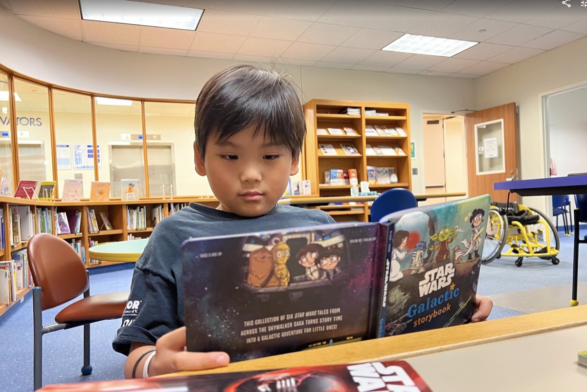 Ryle reading a Star Wars storybook in the school library