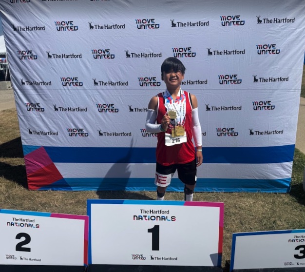 Ryle standing on the number one spot at The Hartford Nationals with medals around his neck