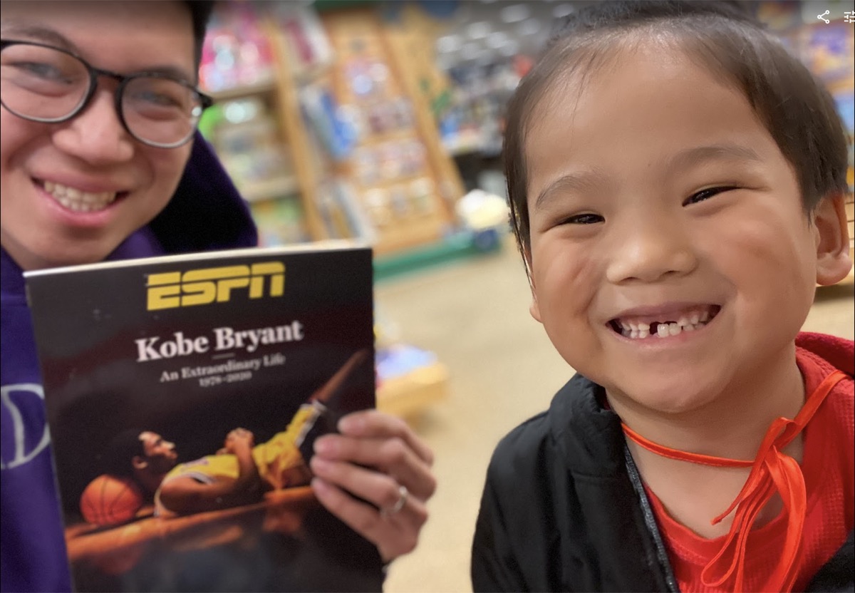 Young Ryle smiling with a Kobe Bryant ESPN book